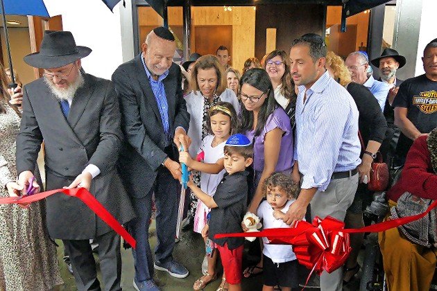 Rabbi Eli Goodman, spiritual leader of Chabad of the beaches, cuts a ceremonial ribbon with Norm and Elaine Brodsky and the Brodskys’ daughter Beth and grandchildren, to dedicate the Norm and Elaine Brodsky Center for Jewish Life.