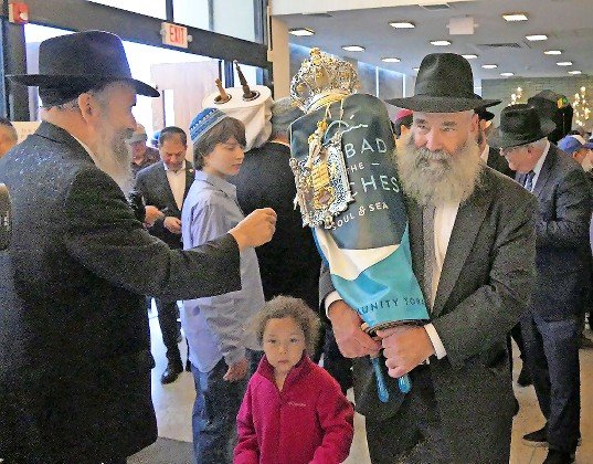 Dr. Doniel Buff, chairman of the Beaches Community Torah Initiative, carries the scroll into the synagogue for the first time.