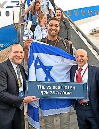 Sam Leeman, the 75,000th Nefesh B’Nefesh oleh, arrived on a Nefesh B’Nefesh charter flight that landed at Ben-Gurion on Aug. 17. He’s flanked by NBN founders Rabbi Yehoshua Fass (left) and Tony Gelbart.