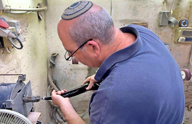 Eli Ribak drilling a mouthpiece into a shofar at the Barsheshet & Ribak shofar factory in Tel Aviv.