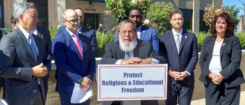 Rabbi Mordechai Kamenetzky of Yeshiva of South Shore, flanked by Nassau County GOP electeds and candidates, speaks against new state rules that would control curricula at yeshivas.