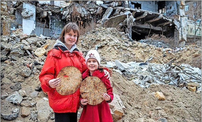 Jewish children in Ukraine hold up shmurah matzah.