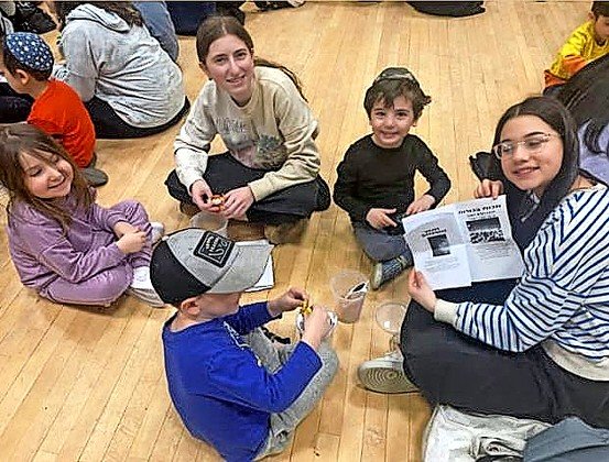 SKA ninth graders and Lev Chana pre-schoolers discuss the ten makkot and the sequence of the seder, using books and props to demonstrate.