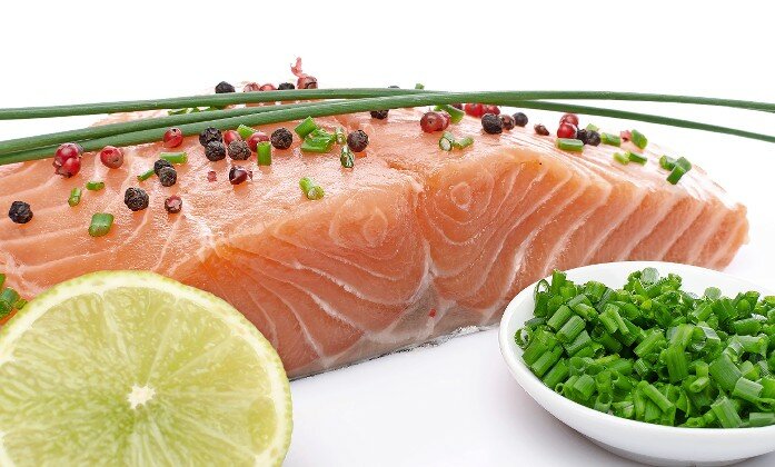 Raw salmon fillet with herbs, lemon and spice.