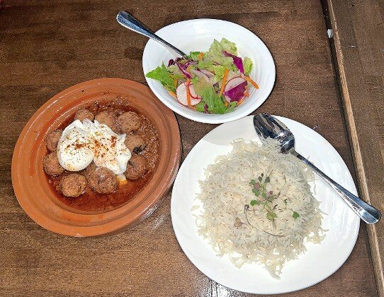 Kefta Tagine features Moroccan spiced meatballs and two poached eggs in a spicy tomato sauce.
