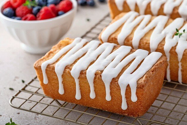 Classic pound cake with powdered sugar glaze dripping over.