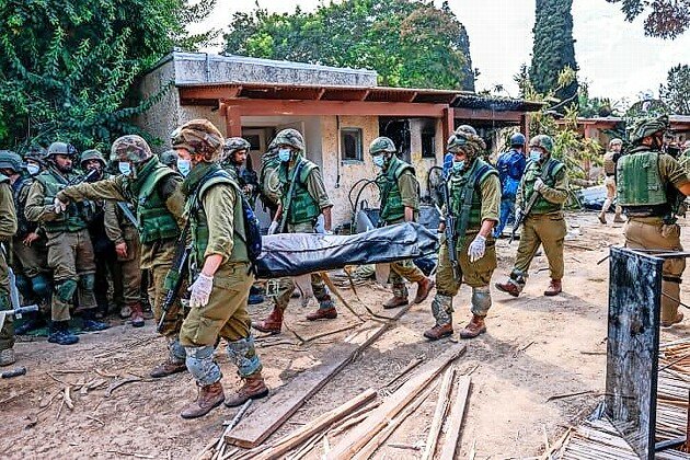 Israeli soldiers remove bodies of Israeli civilians in Kfar Aza, near the Gaza border, on Oct. 10.