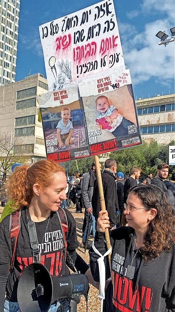 Allie from Tel Aviv holds a sign with a portrait of the Bibas children on Jan. 12.
