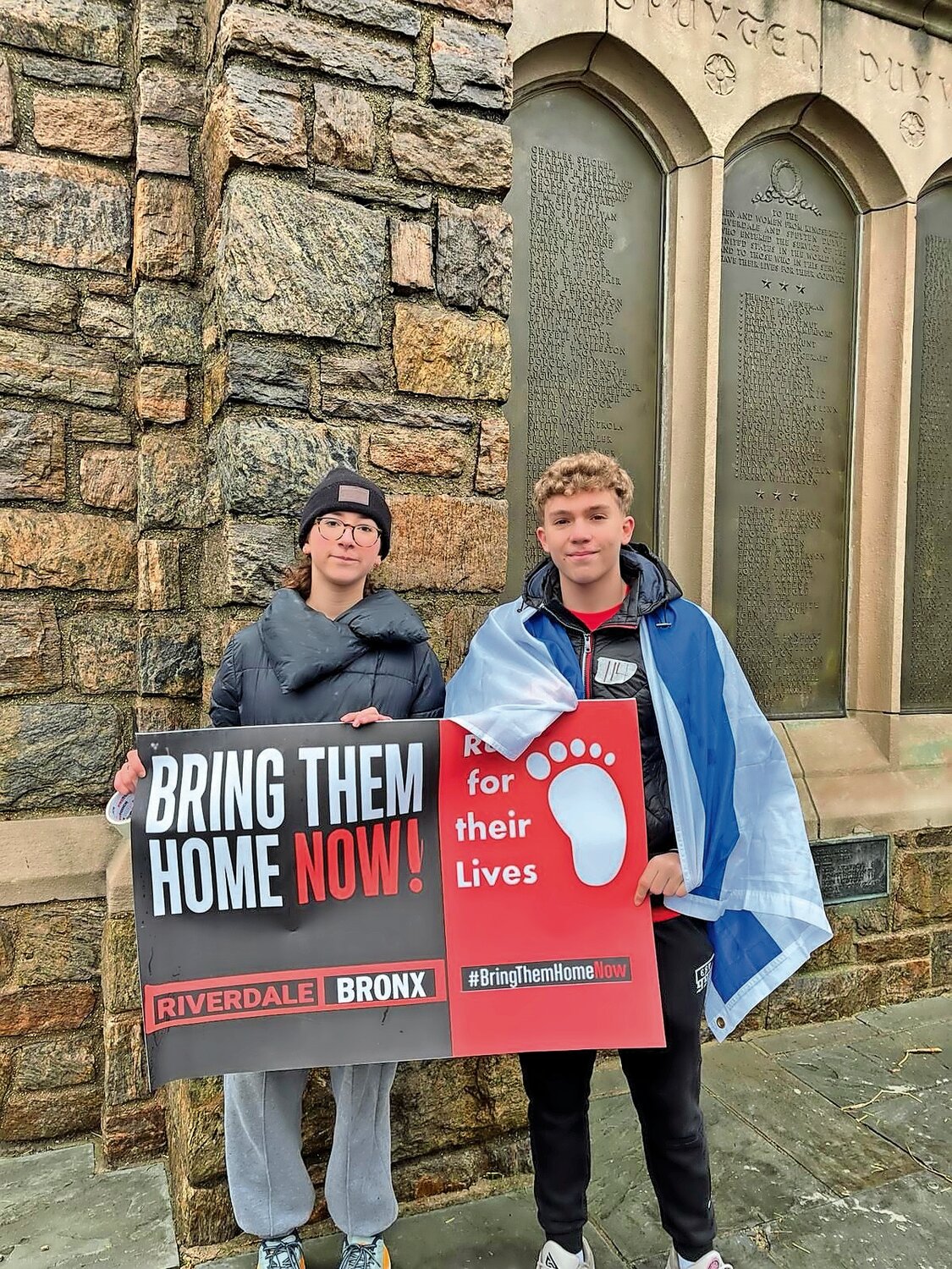 Riverdalians Netta Pack (left) and Ari Vogel, who organized the Riverdale Run For Their Lives, stand for the hostages in front of the Bell Tower on West 239th Street at Riverdale Avenue.