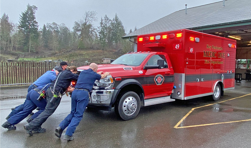 Reenacting a 19th-century tradition, KPFD personnel perform the &ldquo;push-in&rdquo; ceremony with a new ambulance at Longbranch station in February. In the 1800s, horses were unharnessed after returning a fire wagon to its station and firefighters pushed it into the bay.