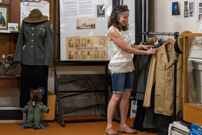 Key Peninsula History Museum Volunteer Nicole Carr tidies up the uniform rack.