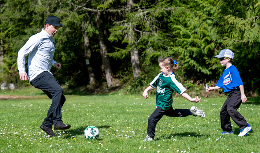 Scott Stone kicking the ball around at Volunteer Park with Harbor Soccer kids Emma, age 6, and Landon, age 8. Tina McKail, KP News