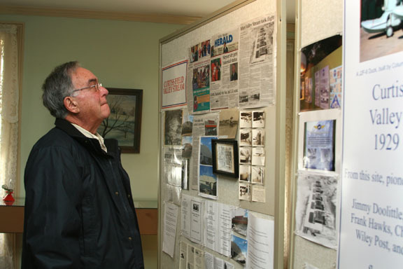 Frank Urgo glances at stories about the history of the old Curtiss Airfield.