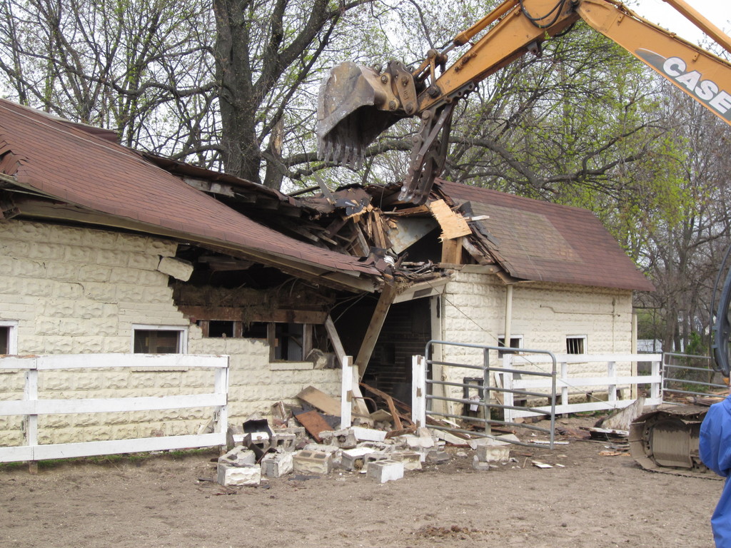 A backhoe slammed into the main barn at Lakewood Stables, demolishing it in a matter of minutes.
