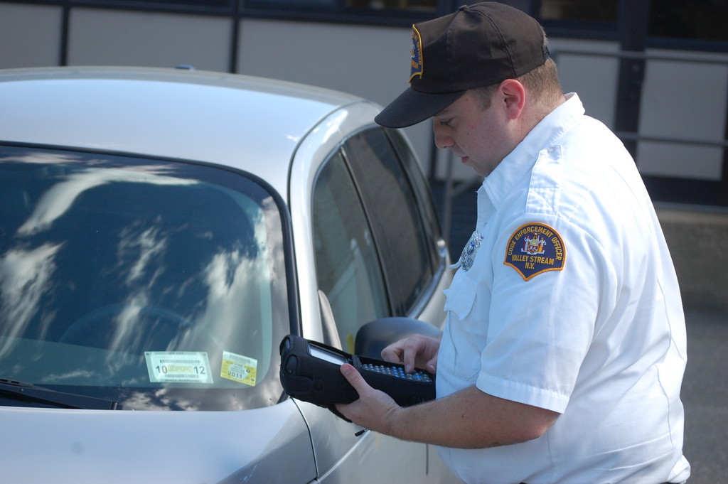 Valley Stream Code Enforcement Officer Joe Sottile uses a new electronic hand-held machine to issue a parking ticket.
