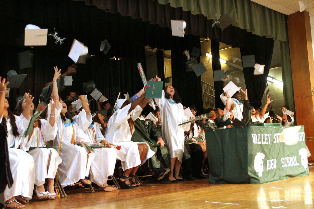 North High School Graduates throw their caps in the air in celebration.