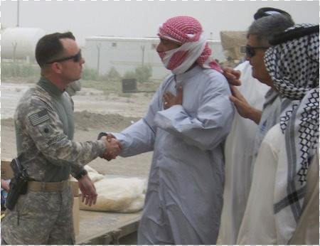 Lt. Col. Robert Wright greets a local Iraqi after he received a humanitarian aid packet.