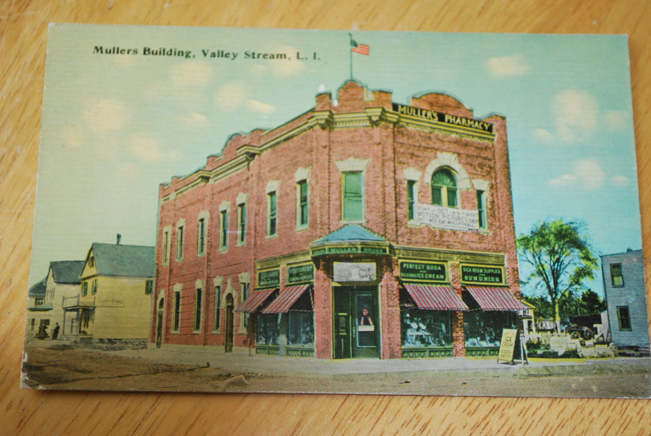 A postcard depicting the Muller’s Pharmacy building on Rockaway Avenue in Valley Stream is part of Barbara Gribbon’s extensive collection.