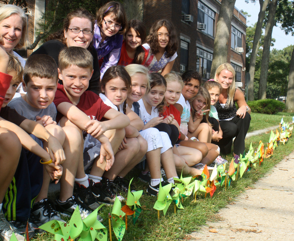 Fourth graders at Lynbrook’s Marion Street School plant Pinwheels for Peace with Principal Barbara Moore, top left, art teacher Patricia Wierzbicki, second from left, and substitute teacher Courtney Tomaini, right.