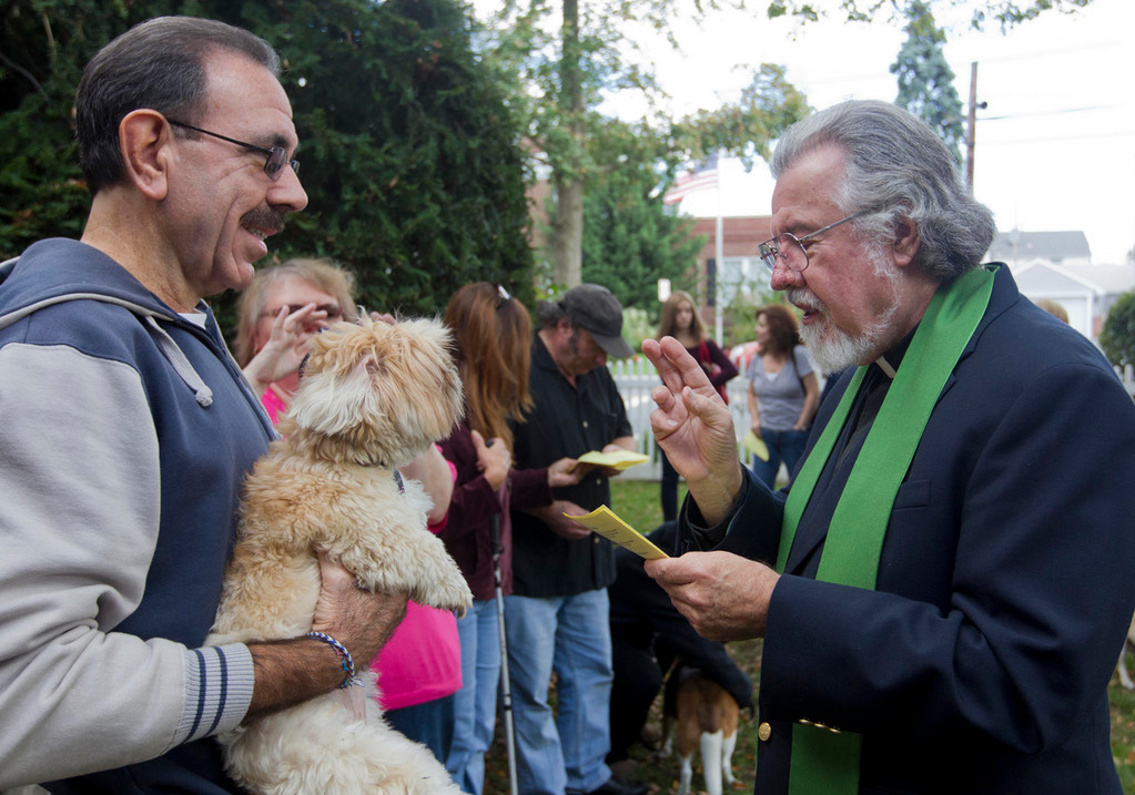 Reverend Eliot Frederic blesses Ernie Adamos dog, Bear.