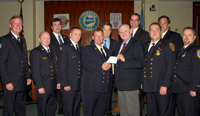 The Lynbrook Chamber of Commerce gave a $1500 donation to the Nassau County Firefighters-Operation Wounded Warrior at a village board meeting on Oct. 3. Pictured are Front row, left: Ex-Captain Steve Grogan, Second Deputy Chief Edward Hynes, Chief Michael Hynes, Ex-Chief Kevin Bien, Bill Gaylor, president Lynbrook Chamber of Commerce, Third Deputy Chief Michael Anderson, and Firefighter Chris Hynes. Back row, left to right: Trustee Alan Beach, Mayor William Hendrick, and trustees Thomas Atkinson and Michael Hawxhurst.