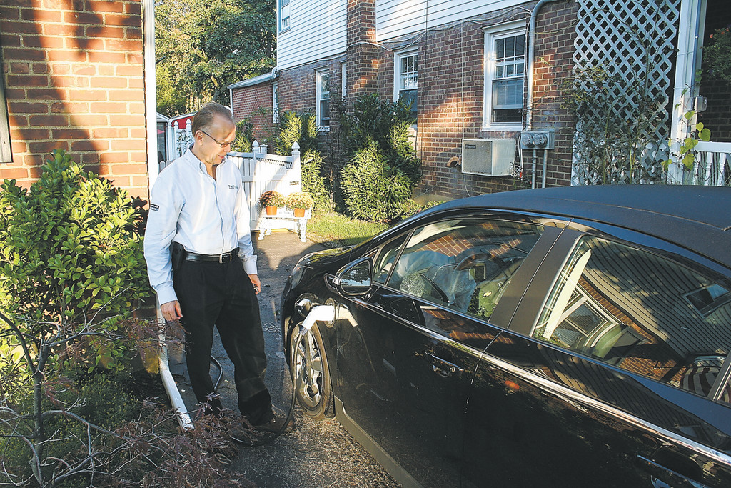 Ed Olsen with his solar-powered Chevy Volt. He estimates that he will save $1,500 in gas.