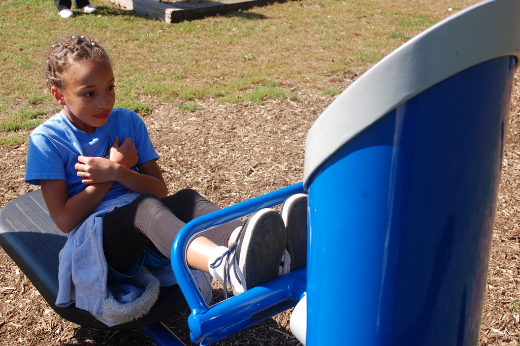 Catherine Rivera, a fourth-grader, demonstrates how to use one of the fitness stations to do crunches.