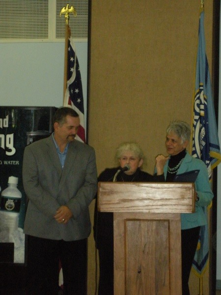 Village Recreation Director Pat McDermott, left, listens as Lazarus and Carol Ann Pagano say a few words to the crowd.