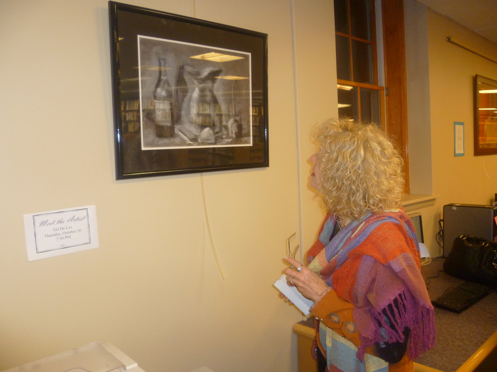 Gloria Elliott looks at a black and white painting by Gilda De Lio at the East Rockaway Library.