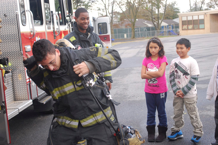 Elie Karkini puts on all the gear that firefighters wear so children won’t be afraid.