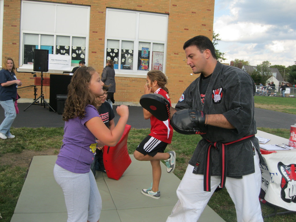 Dave Herman, owner of New Generation Karate in Franklin Square, taught a Polk Street student some basic karate moves at the Fall Festival.