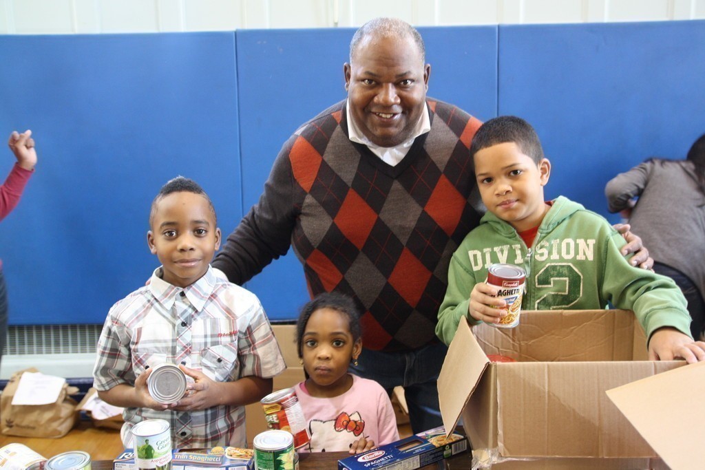 Xavier, an Elmont 3rd grader, left, Tia, 3, and Andrew, an Elmont 	sixth-grader, volunteered at the Elmont Dads’ Club/Student Council food drive on Nov. 18, along with Elmont Union Free School District superintendent Al Harper.