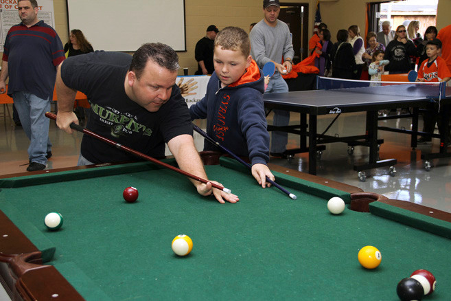 Bill Hyland shows his son, Billy the proper way to play pool.