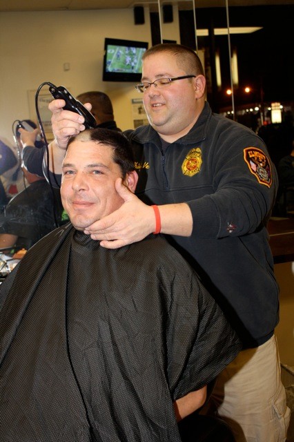 Probationary firefighter Scott Sheldon, left, received a haircut by ex-Chief Pedro Vera Jr. of Elmont Fire Dept Engine 2 on Dec. 12, at The Shop's "Haircuts for Elmont Firefighter Richard Schriefer."