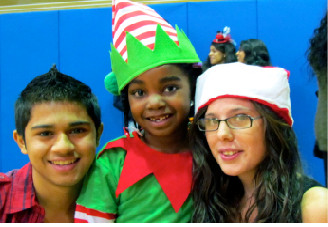 Sewanhaka 12th-grader Muhammad Ghafoor, left, and 11th-grader Jessica Pemberton, right, posed with a Covert Avenue first-grader after the play last week.