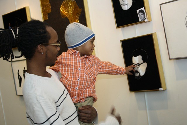 Donald Morency of Elmont and his son, Antoine Eric St. Clair Morency, 1, visited the Elmont Memorial Library recently to see artwork commemorating Black History Month, such as this piece portraying Malcolm X. Story, page 10. At Right, Sen. Jack Martins honored Gene Grant with a Dr. Martin Luther King Jr. Award at the annual Black History Month Celebration in Elmont on Feb. 13.