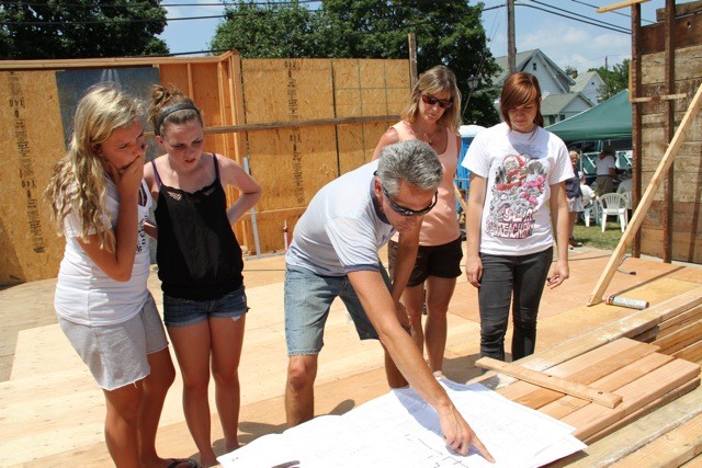 Ray Strasser, of Habitat for Humanity, showed Brittany Chajkewicz, left, Kiera Grassi, Kathy Voellm and Melissa Voellm the plans for the Mineola house last spring.
