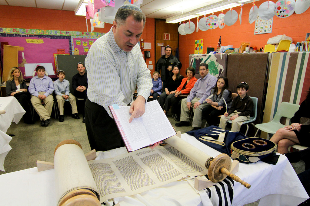 Parents and children listened as Lev Herrnson explained the Torah writing traditions