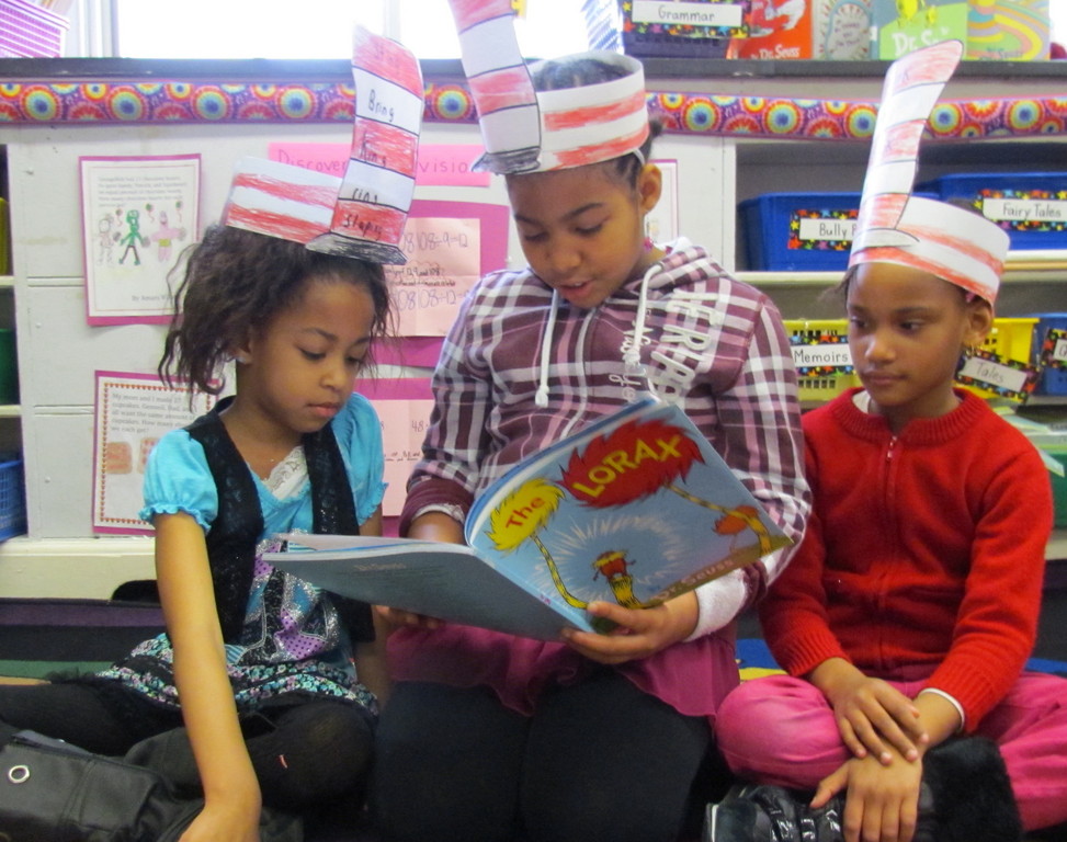 Alden Terrace third-grader Maya Martin read “The Lorax” to first-grade students Ayanna Hunt and Alyssa DeMendonca on March 2.