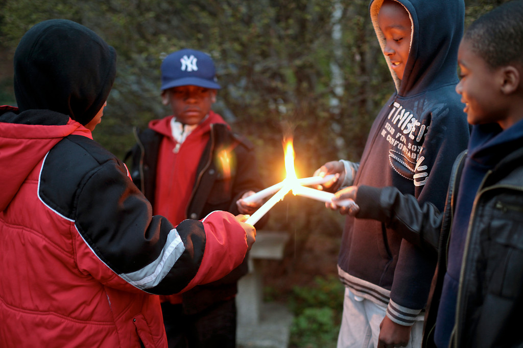 Vaughn Highland, left, 7, Tristen Davis, 7, Trey Harts, 9, and Tyler Harts, 7, shared candlelight last week at Elmont Road Park during a vigil for Trayvon Martin, the Florida teen who was shot and killed on Feb. 26.