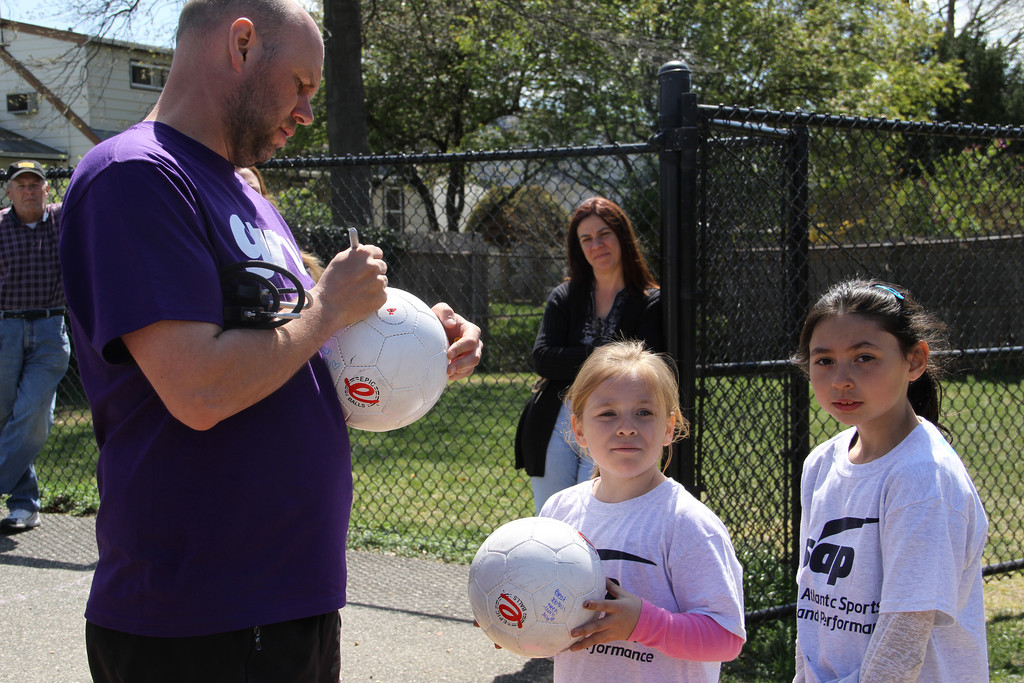 Leigh Pilkington, president of Atlantic Sports and Performance, signed soccer balls for local students after the organization's Franklin Square soccer camp.