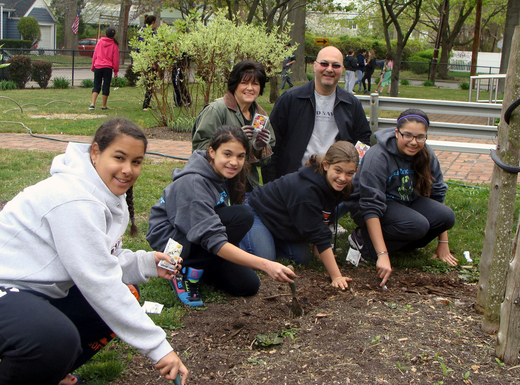 The group planted flower seeds around a tree in front of the Grist Mill Museum. From left were eighth-grader Alexis Guner, and seventh-graders Jasmine Jimenez, Joanna Ambrosio and Demi Lonergan. They were supervised by Beautification Committee Chairwoman Rose Trum and Kiwanis President Carmine Tufano.