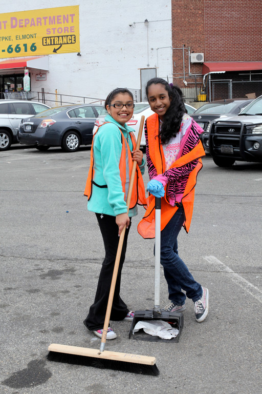 Carla Ojeda, 11, left, and Roxanne Edwards, 11, worked together on April 21 to sweep a parking lot located along Hempstead Turnpike in Elmont.