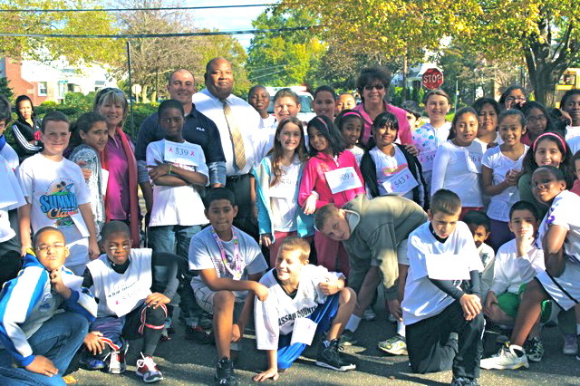 More than 400 fourth-, fifth- and sixth-graders from Stewart Manor School — one of five schools in the Elmont Union Free School District — ran the school’s 1,200-meter “Prediction Marathon” in October. The students posed with Superintendent Al Harper, center, after the race.