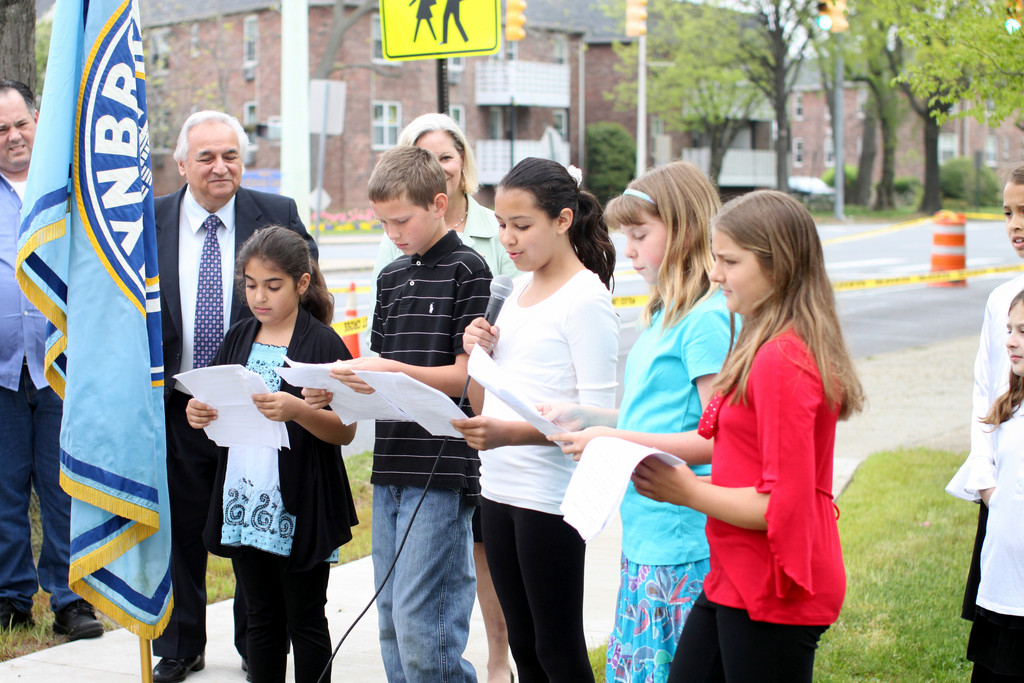 Marion Street students Elise Candreva, left, James Montgomery, Angelina Chirichella, Bernadette Kilkelly, and Kathryn Bamman read the top 10 reasons why Lynbrook is a great place to be, which was part of their contribution to the time capsule. Superintendent Santo Barbarino, far left, looks on.