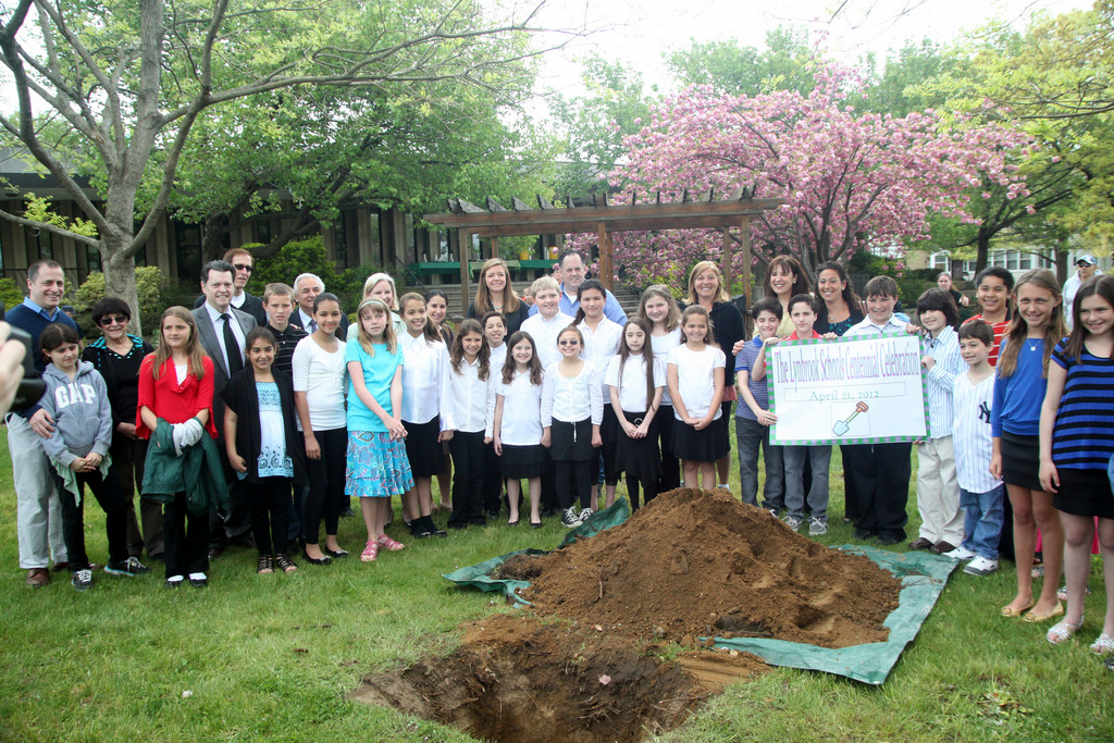 The participants gather around the hole where the time capsule will be lowered.