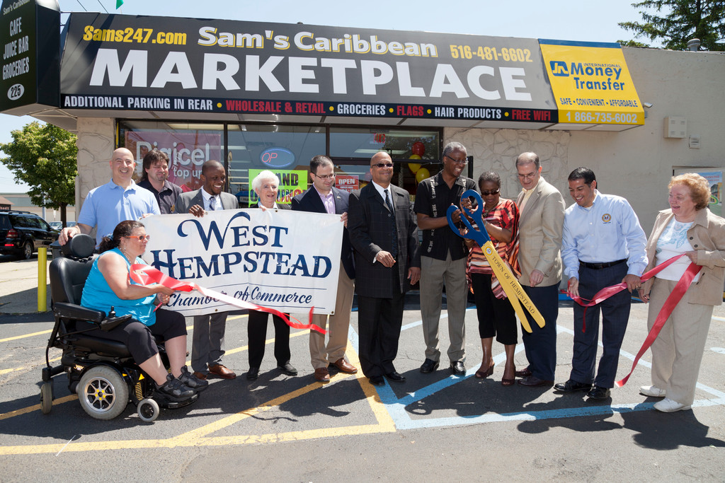 The West Hempstead Chamber of Commerce held ribbon cuttings for three new businesses in the community on May 19. Andrew Morris, with scissors, celebrates his new business, Sam’s Caribbean Market.