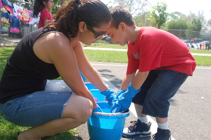 Sharon Benyaminy, a Student Council advisor at Forest Road School, helped first grader Gavin Benavides tie-dye a T-shirt on May 29 as part of an anti-bullying program.