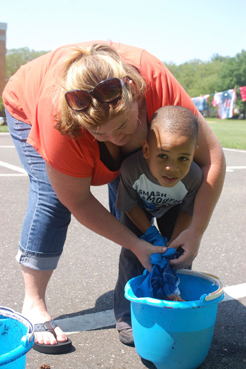 Forest Road School Principal Erin Malone helps kindergartner Michael Johnson color a shirt.