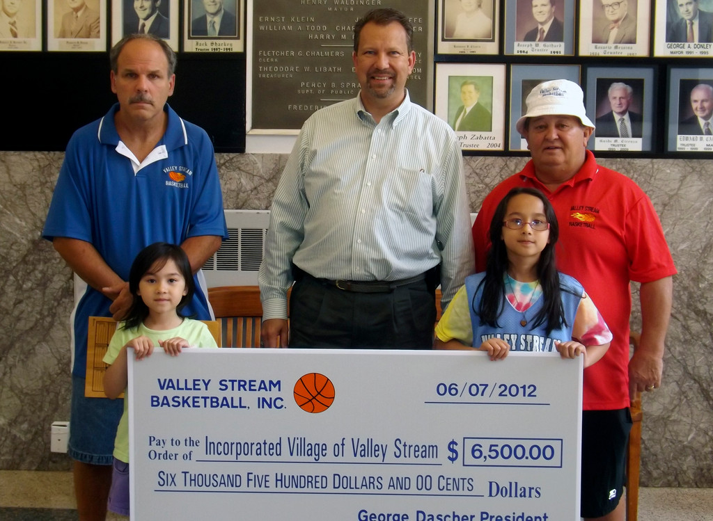 A large check was presented to Mayor Ed Fare, center, on June 7 by Valley Stream Basketball, Inc. Vice President Sal Dilapi, left and President George Dascher presented to check with Gabrielle, left, and Danielle who play in the league.